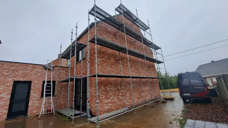 Tijdens de voegwerken in Putte, waarbij de gevel zorgvuldig wordt ingevoegd met licht beige voegmortel.